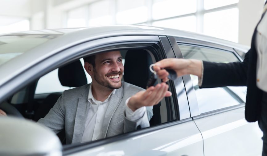 Portrait of happy customer buying new car in salon